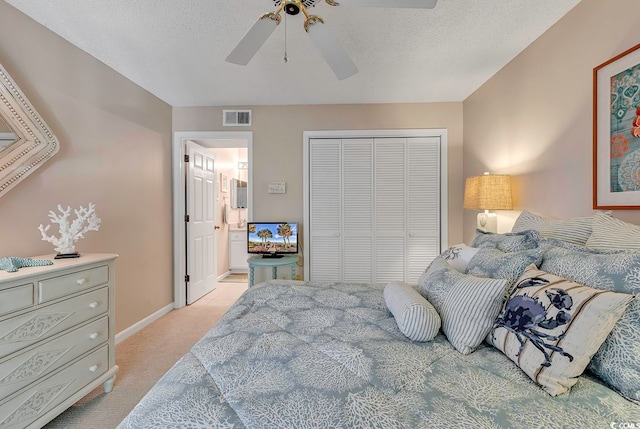 carpeted bedroom featuring a closet, a textured ceiling, and ceiling fan