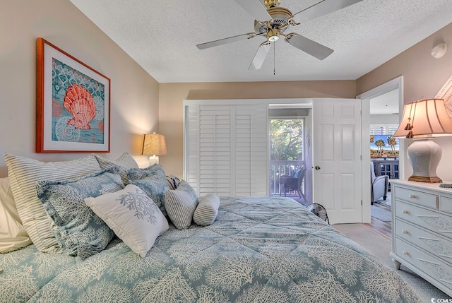 carpeted bedroom with a textured ceiling, ceiling fan, and access to exterior