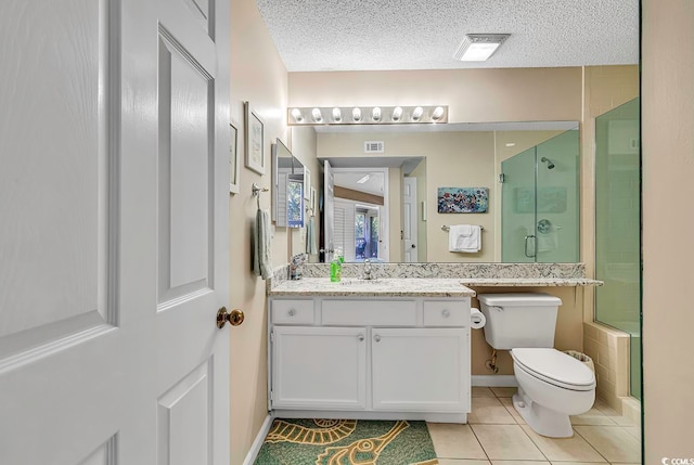 bathroom with a textured ceiling, large vanity, tile floors, and toilet