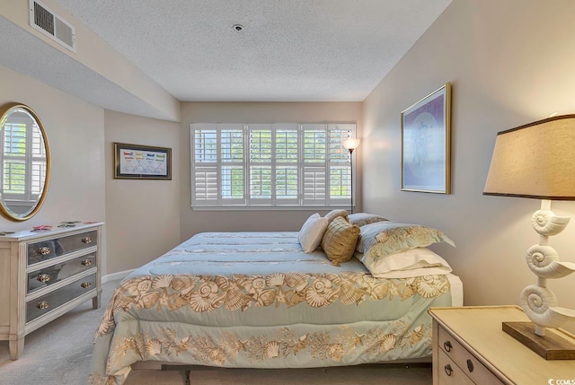 bedroom featuring a textured ceiling and carpet flooring