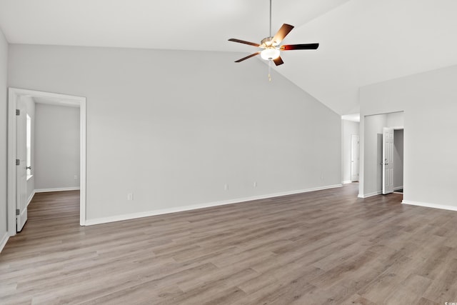 empty room with high vaulted ceiling, ceiling fan, and light hardwood / wood-style floors