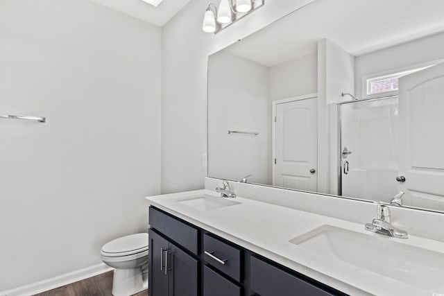 bathroom with a shower with shower door, toilet, vanity, and wood-type flooring