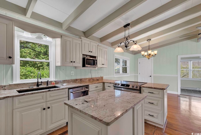 kitchen with appliances with stainless steel finishes, sink, a center island, and a healthy amount of sunlight