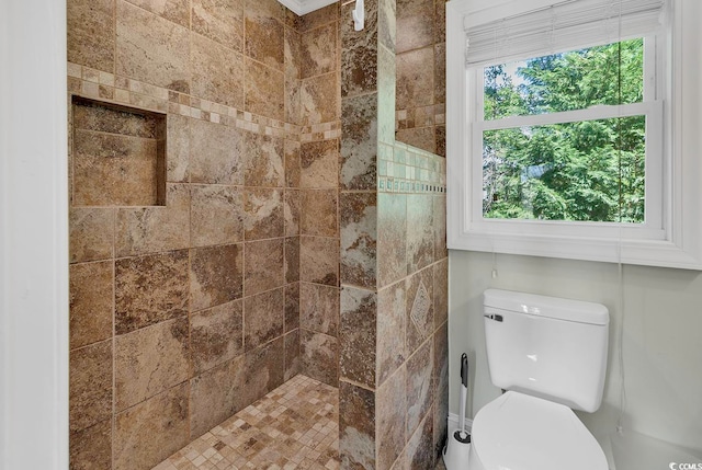 bathroom featuring toilet and a tile shower