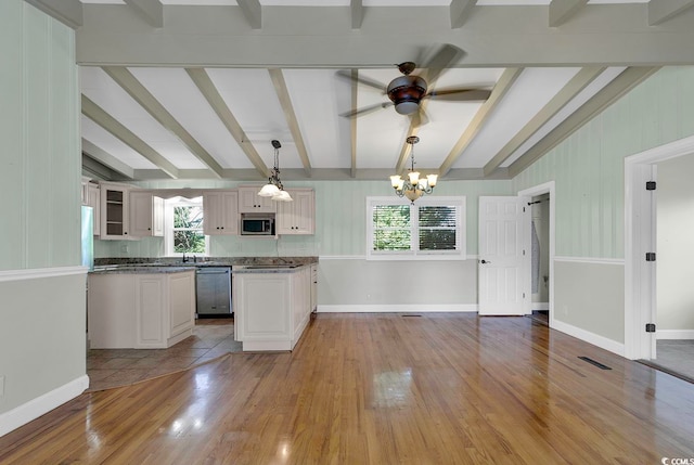 kitchen with beamed ceiling, appliances with stainless steel finishes, light tile floors, ceiling fan with notable chandelier, and hanging light fixtures