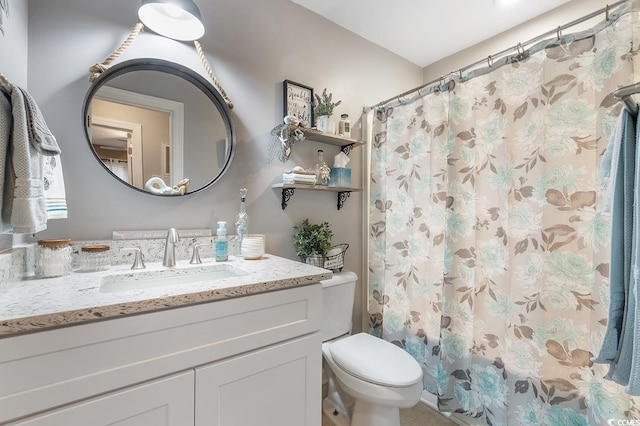 bathroom featuring toilet, a shower with shower curtain, and vanity