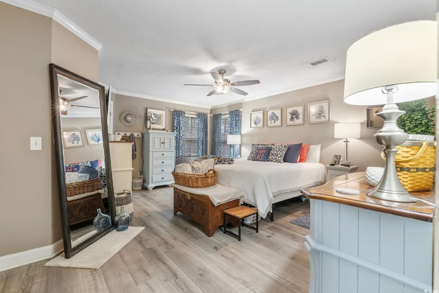 bedroom with a ceiling fan, visible vents, baseboards, ornamental molding, and light wood finished floors