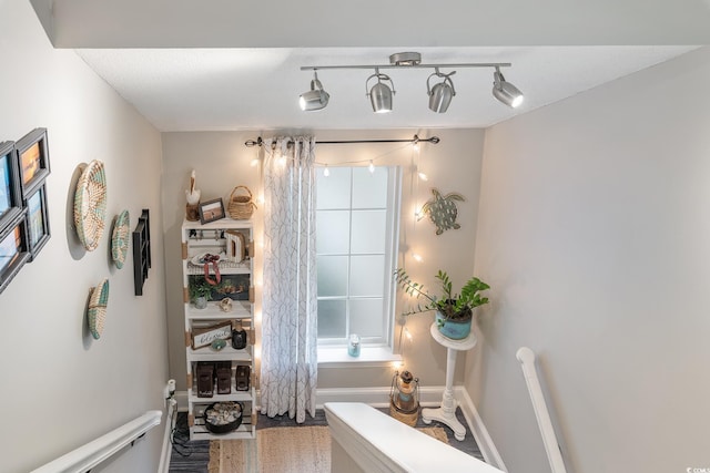 interior space featuring rail lighting and baseboards