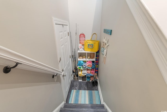 staircase featuring baseboards and wood finished floors