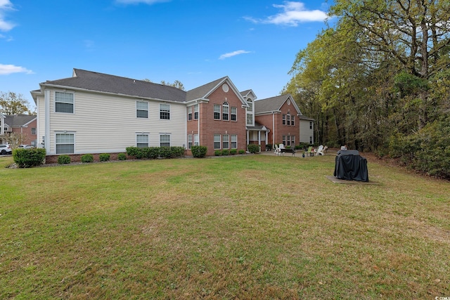 rear view of property with a yard and a patio area