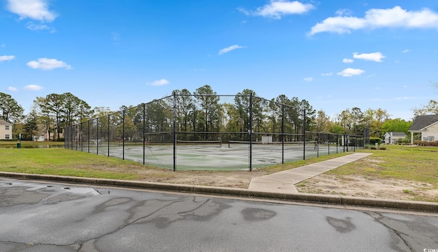 view of community with a tennis court and fence