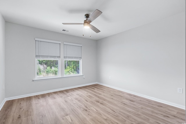 empty room with ceiling fan and light hardwood / wood-style flooring