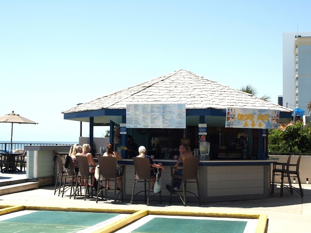 back of property featuring an outdoor bar and a patio area