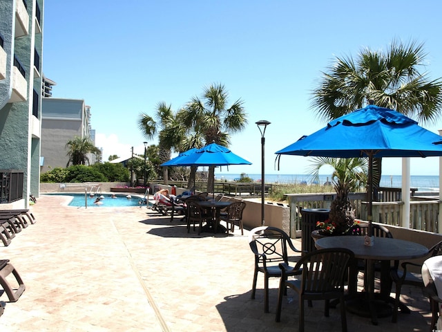 view of terrace featuring a community pool and a water view