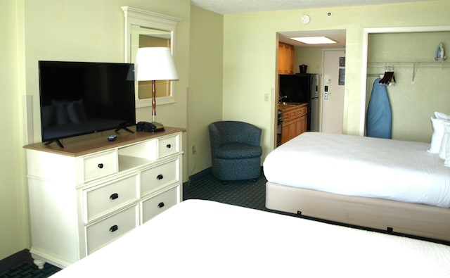 carpeted bedroom featuring black fridge