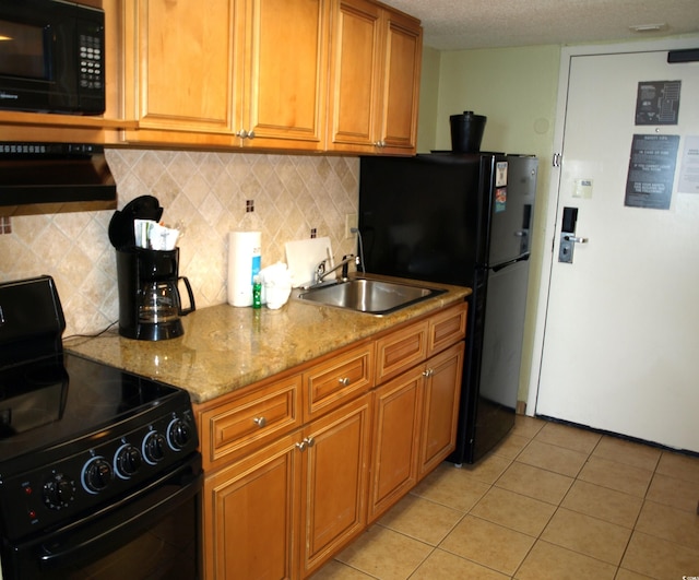 kitchen featuring light stone countertops, black appliances, sink, light tile floors, and tasteful backsplash