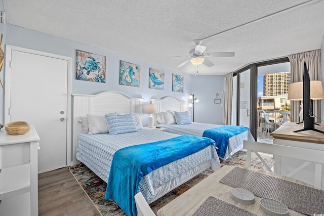 bedroom with wood-type flooring, ceiling fan, and a textured ceiling