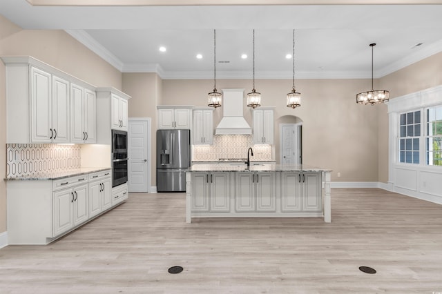 kitchen with premium range hood, decorative light fixtures, white cabinetry, and appliances with stainless steel finishes