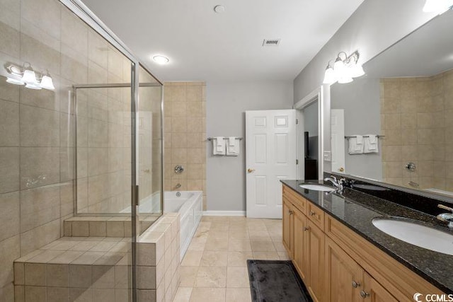 bathroom featuring double vanity, tile floors, and tiled bath