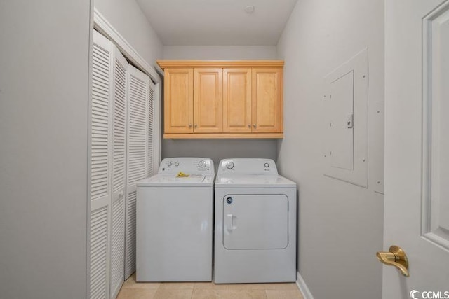 laundry room with cabinets, washing machine and dryer, and light tile floors