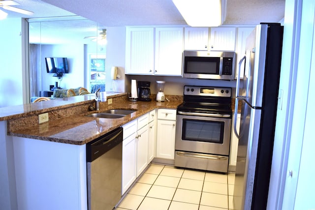 kitchen with kitchen peninsula, white cabinetry, sink, and stainless steel appliances