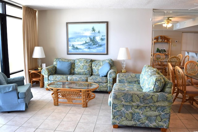 living room featuring ceiling fan, light tile patterned floors, and a textured ceiling