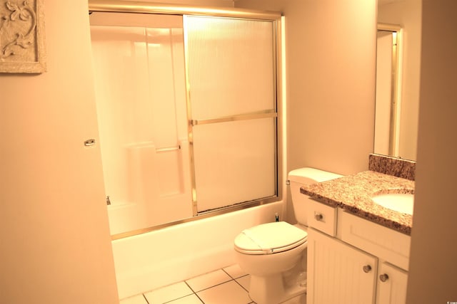 full bathroom with tile patterned flooring, vanity, bath / shower combo with glass door, and toilet