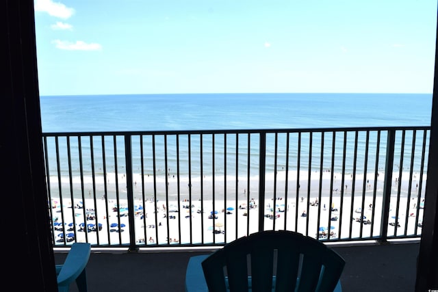 balcony featuring a water view and a beach view