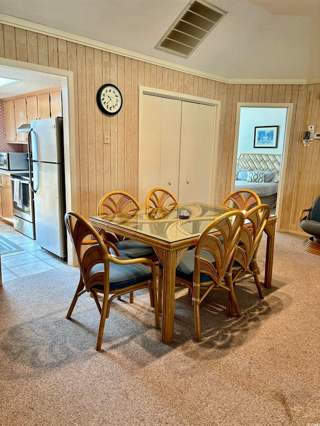 dining space with wooden walls and light tile floors