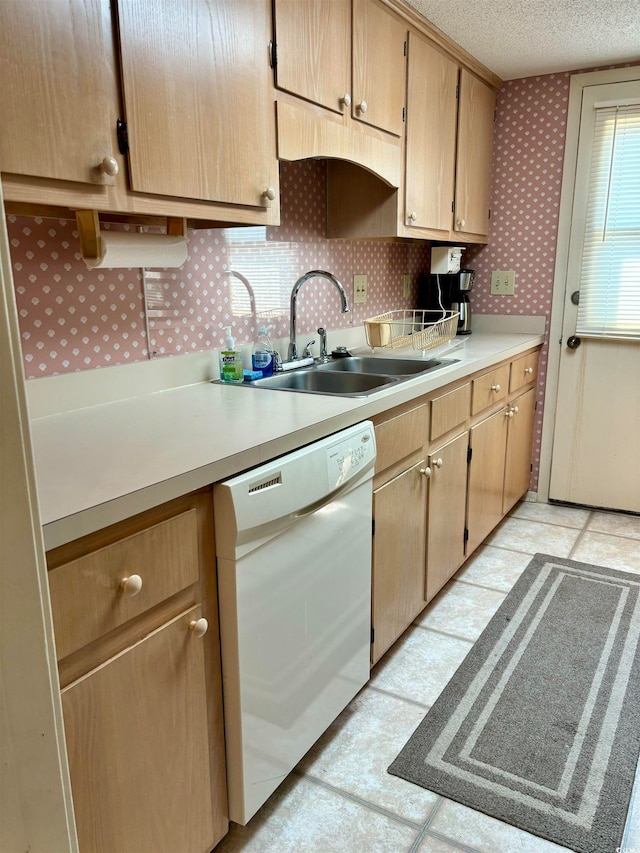 kitchen with dishwasher, a textured ceiling, tasteful backsplash, sink, and light tile floors