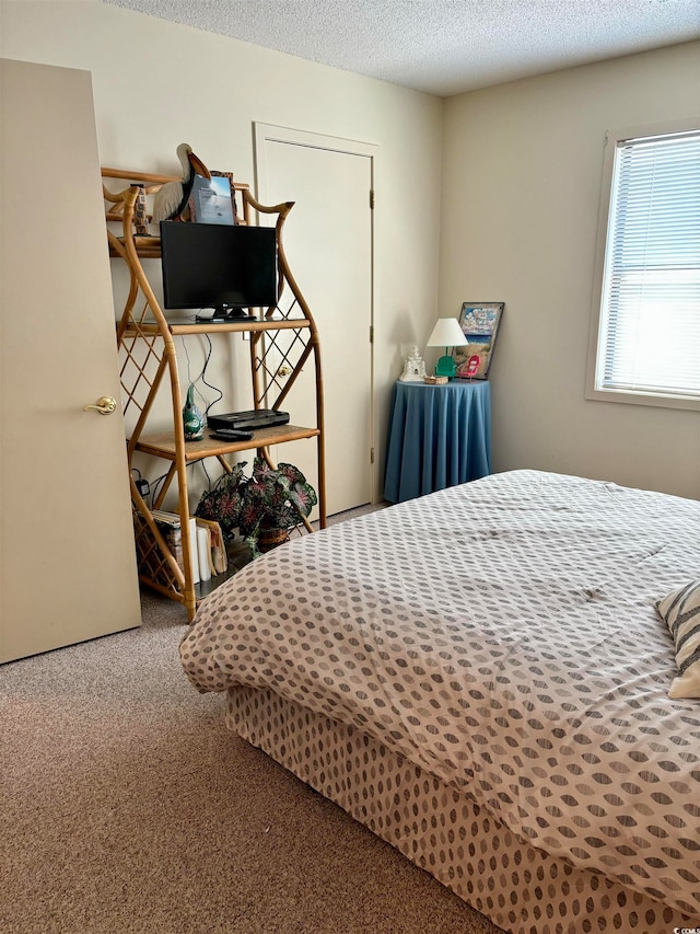 carpeted bedroom featuring a textured ceiling