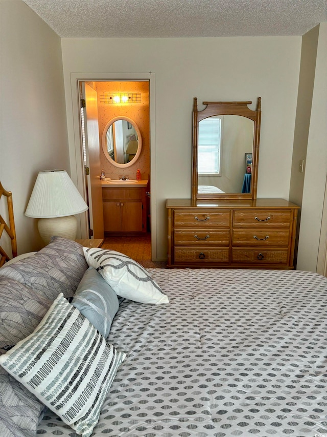 bedroom with a textured ceiling and ensuite bathroom