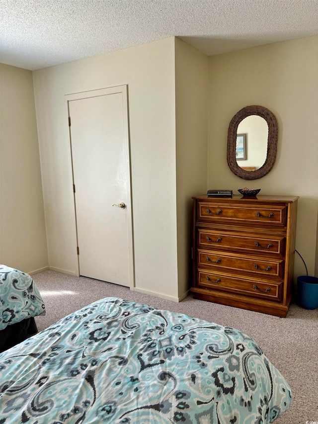 bedroom featuring a textured ceiling, a closet, and carpet floors