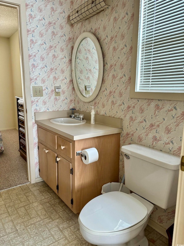 bathroom with toilet, tile flooring, vanity, and a textured ceiling