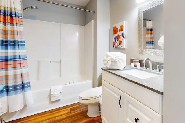 full bathroom with hardwood / wood-style flooring, vanity, shower / bath combo, and toilet