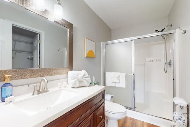 bathroom featuring an enclosed shower, toilet, vanity, and hardwood / wood-style flooring