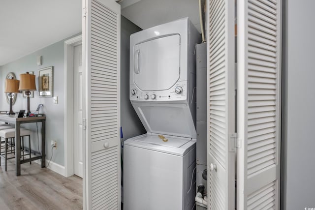 laundry room with stacked washing maching and dryer and light wood-type flooring