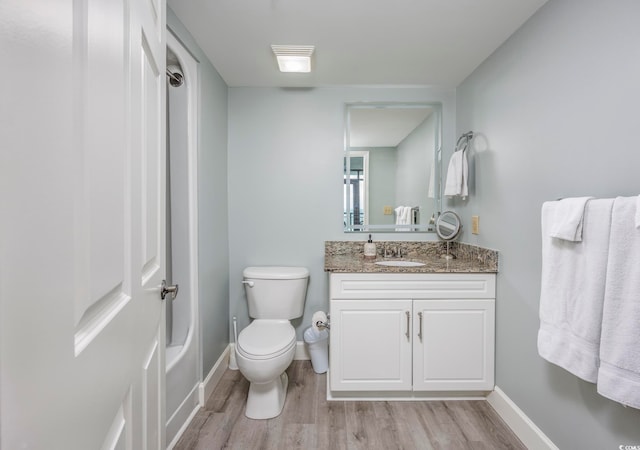 full bathroom featuring shower / bath combination, hardwood / wood-style floors, vanity, and toilet