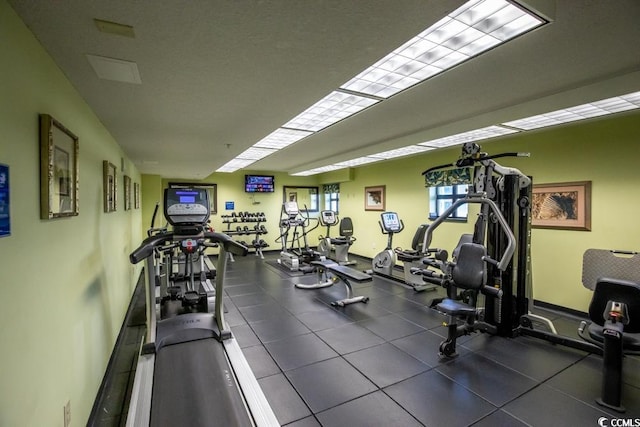 exercise room with dark tile floors