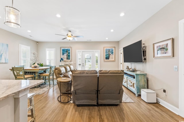 living room featuring light hardwood / wood-style flooring, french doors, and ceiling fan