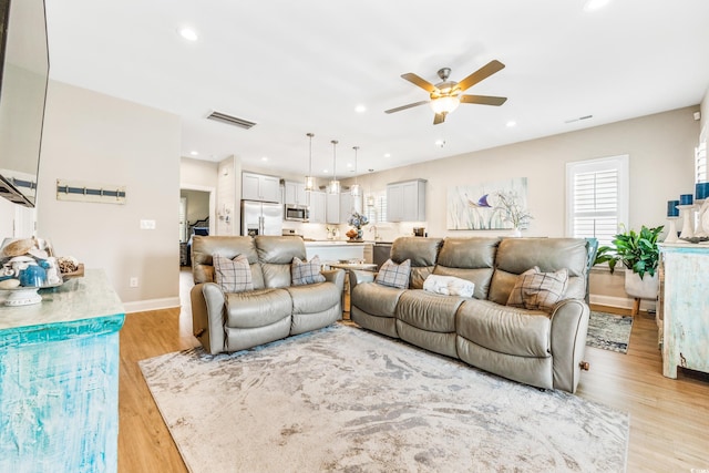 living room with ceiling fan and light hardwood / wood-style floors