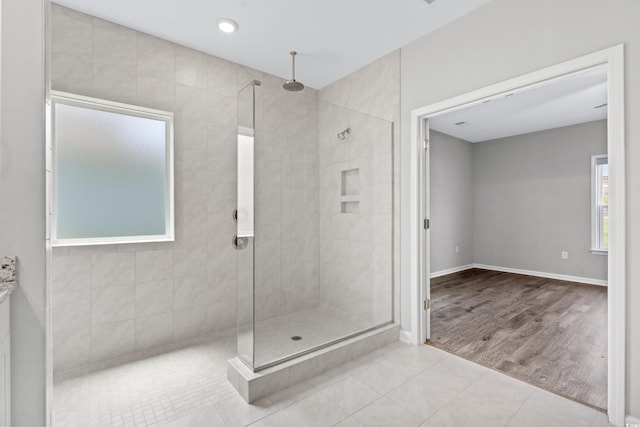 bathroom with hardwood / wood-style flooring and tiled shower