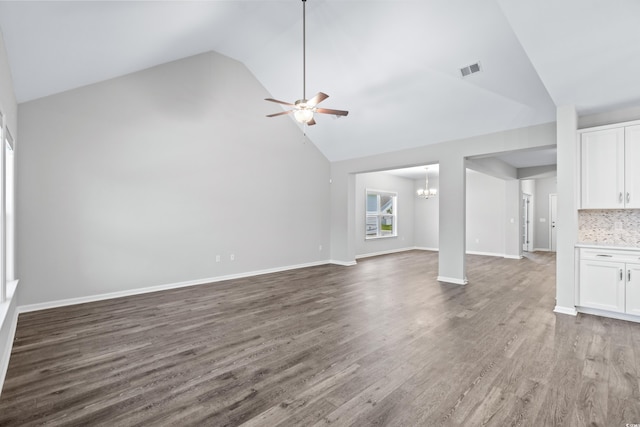 unfurnished living room featuring ceiling fan with notable chandelier, wood-type flooring, and high vaulted ceiling