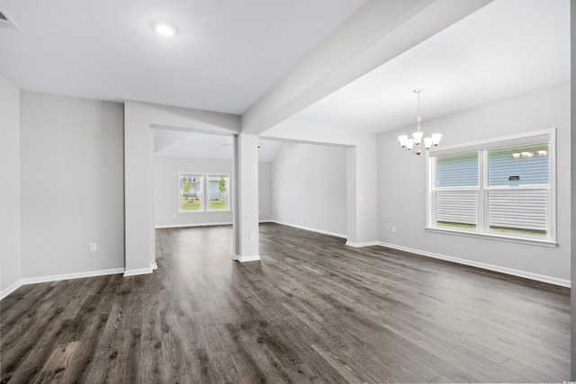 unfurnished living room with dark hardwood / wood-style floors and an inviting chandelier