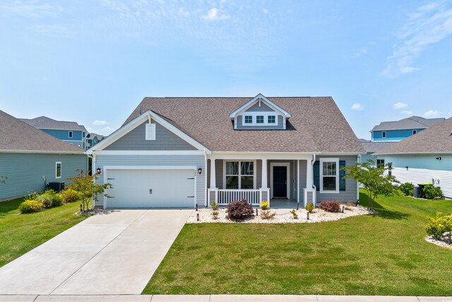 view of front of property featuring a front lawn, a garage, covered porch, and central AC unit