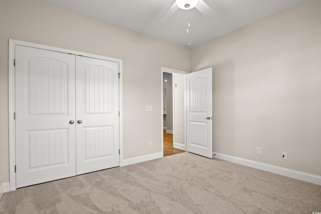 unfurnished bedroom featuring light carpet, ceiling fan, and a closet