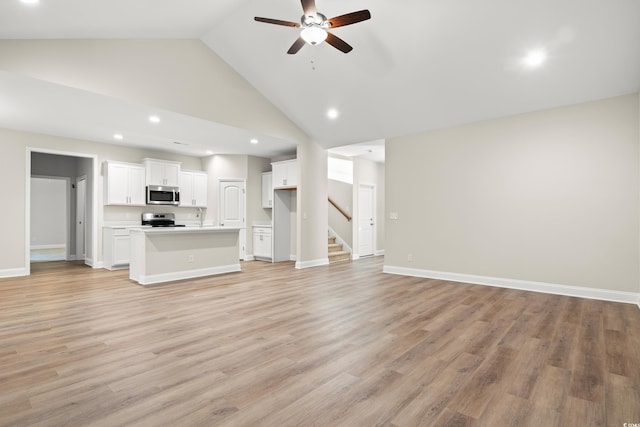 unfurnished living room with ceiling fan, high vaulted ceiling, and light hardwood / wood-style flooring