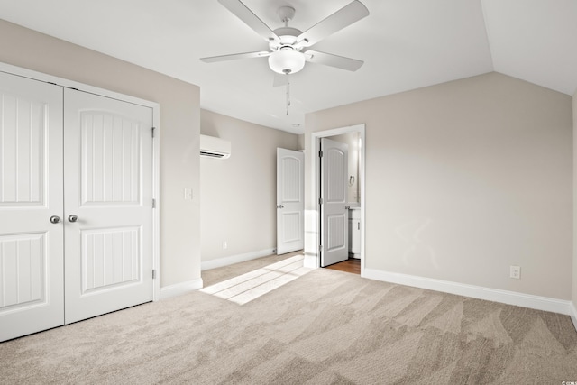 unfurnished bedroom with ceiling fan, a wall unit AC, light carpet, vaulted ceiling, and a closet