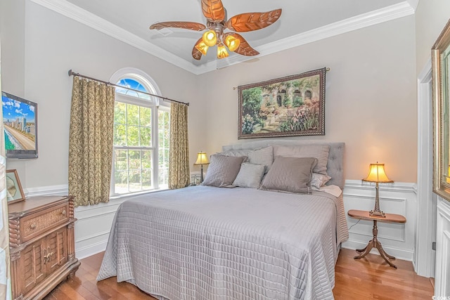 bedroom with ceiling fan, crown molding, and light wood-type flooring