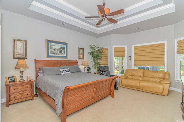 bedroom featuring light colored carpet, a raised ceiling, ceiling fan, and ornamental molding